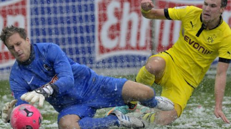 Olivers Baumans un Kevins Groskroics uz piesnigušā Freiburgas stadiona zāliena
Foto: AFP/Scanpix