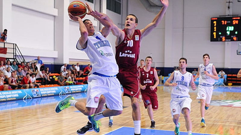 U18 izlases aizsargs Džeiks Eduards Krūmiņš cenšas apturēt Itālijas junioru izlases līderi Federiko Musīni.
Foto: FIBAEurope.com