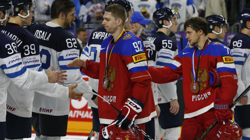 Jevgeņijs Kuzņecovs un Artemijs Panarins ar medaļām kaklā atsveicinās no Somijas izlases hokejistiem
Foto: Reuters/Scanpix