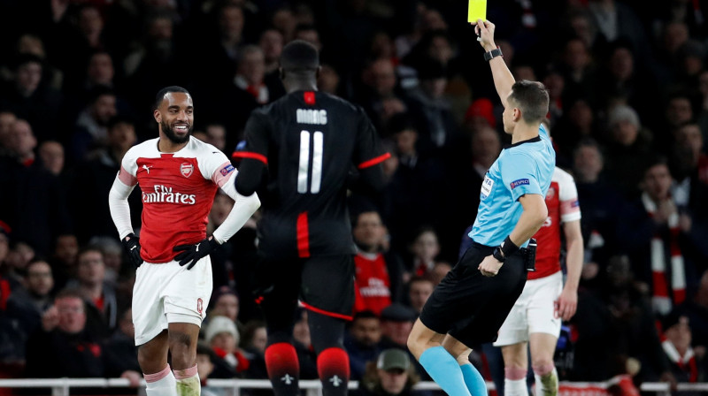 Andris Treimanis piešķir dzelteno kartīti Londonas "Arsenal" futbolistam Aleksandram Lakazetam. Foto: Tony O'Brien/Action Images via Reuters/Scanpix