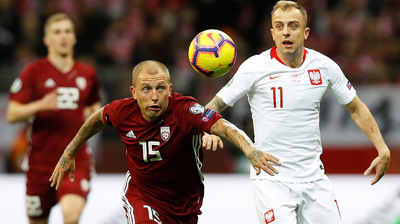 Deniss Rakels cīņā ar Kamilu Grosicki. Foto: Reuters/Scanpix