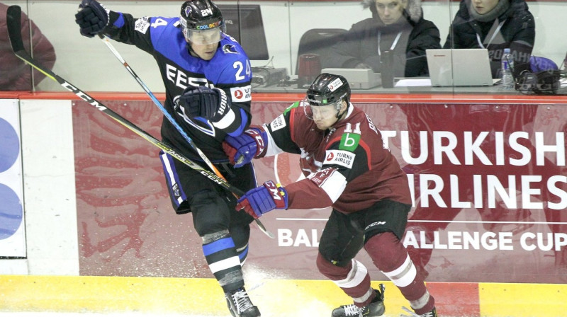 Ričards Bernhards (pa labi) cīņā ar Aleksandru Petrovu. Foto: Hockey Lietuva