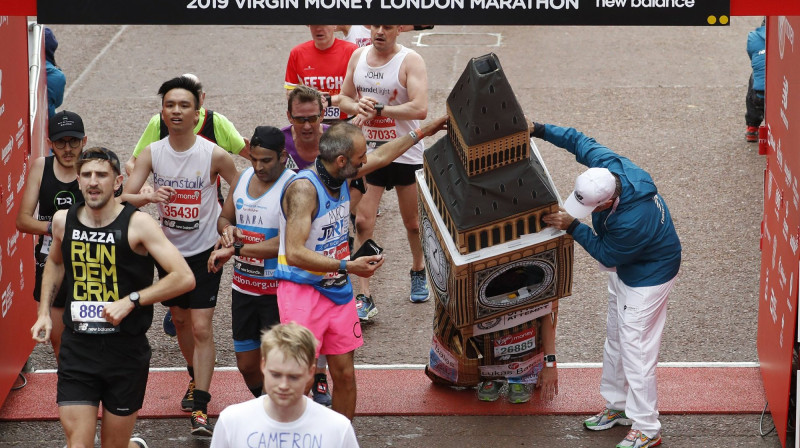 Londonas Bigbens šķērso maratona finišu. Foto: AP Photo/Alastair Grant