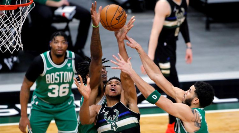 Jannis Adetokunbo uzbrukumā pret diviem "Celtics" spēlētājiem. Foto: AP/Scanpix