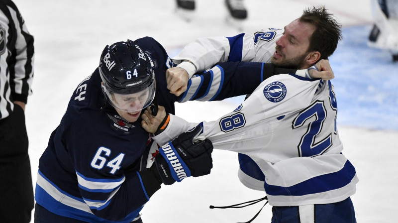 Vinipegas "Jets" aizsargs Logans Stenlijs pret Tampabejas "Ligjhtning" uzbrucēju Zemgus Girgensonu. 
Foto: Fred Greenslade/AP/Scanpix