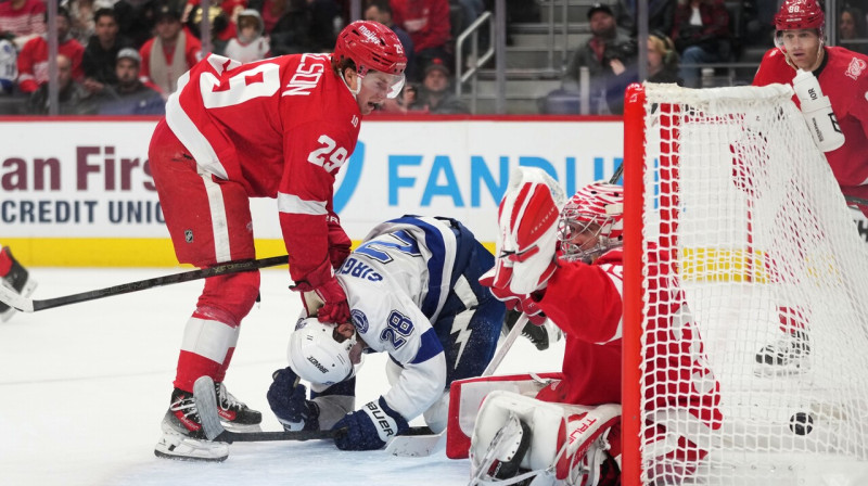 Zemgus Girgensons padara darbu vārtu priekšā, bet ripa ielido Detroitas "Red Wings" vārtsarga Džona Gibsona cietoksnī. Foto: Ryan Sun/AP/Scanpix