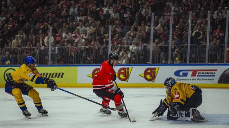 Ķelnes "Haie" hokejists izrāvienā pret Herningas vārtsargu Jāni Feceru. Foto: Johnny Brungs